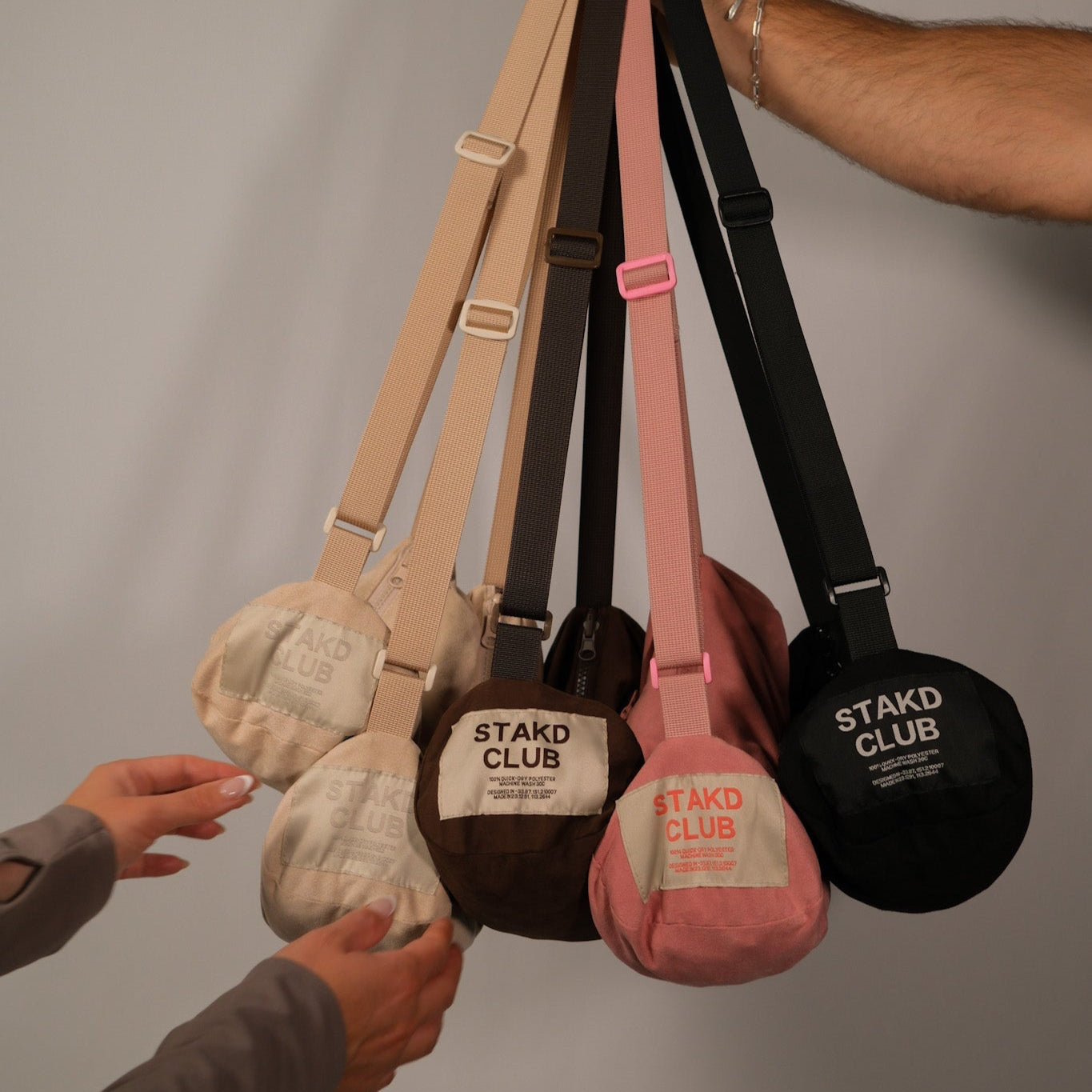All STAKD CLUB Grab Towel colours — beige, pink, brown and black — shown as bags