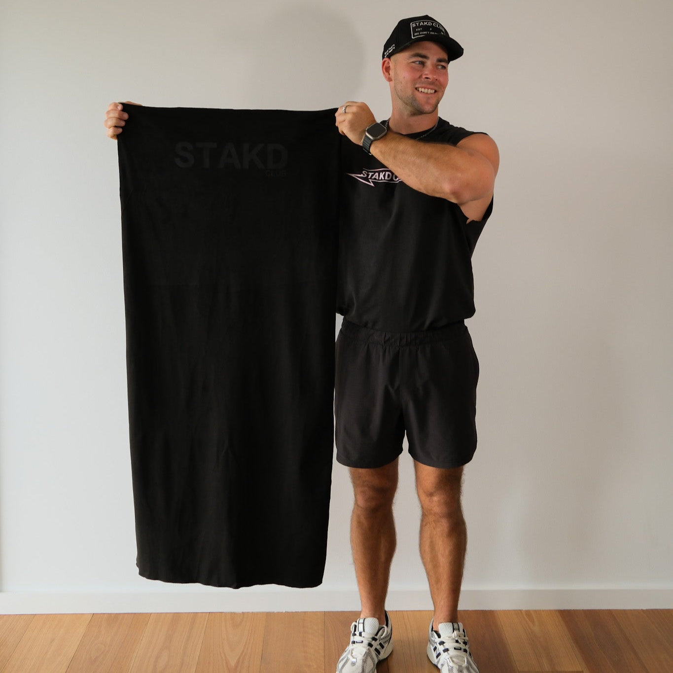 Man holding a black towel with 'STAR' branding against a plain wall.