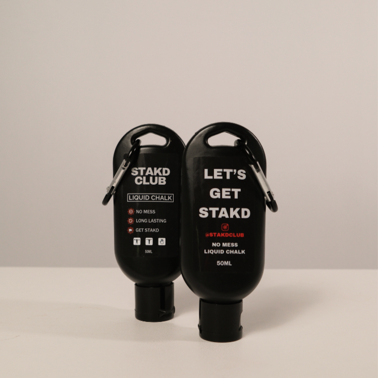 Two black liquid chalk bottles with carabiners on a beige background